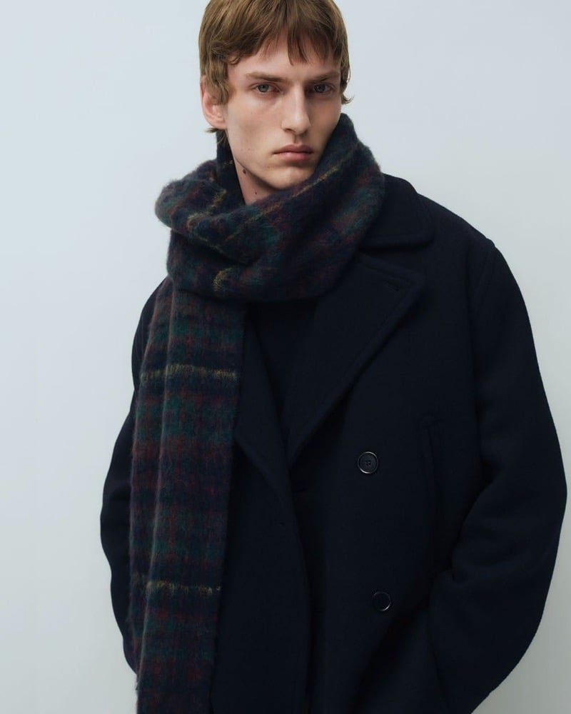 Tammo Rahming in a double-breasted wool coat with a brushed check scarf wrapped around his neck