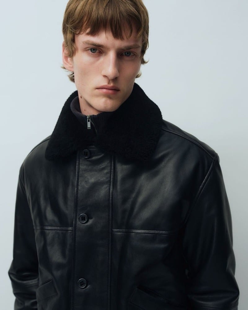 Close-up of Tammo Rahming in a leather jacket with a shearling collar and a zip-neck knit underneath