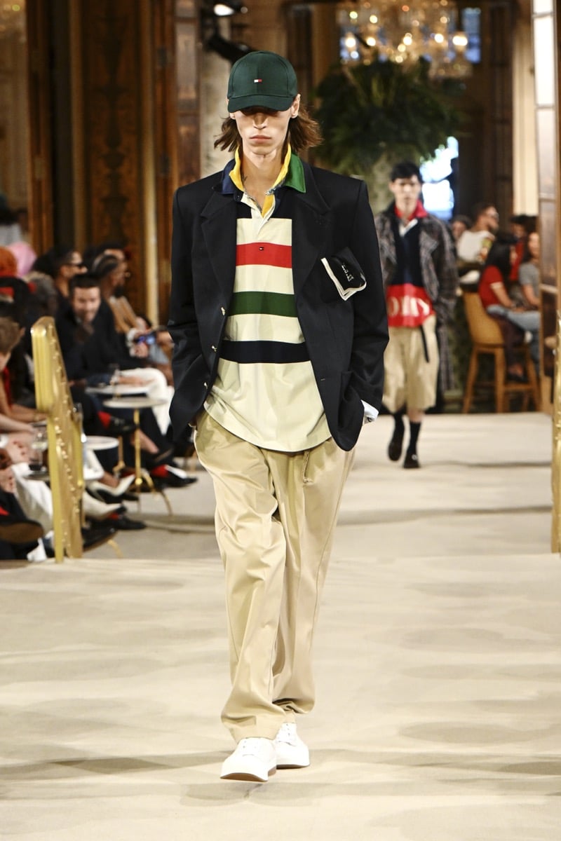 A model in a green cap and blazer over a striped wordmark polo, with khaki trousers, for Tommy Hilfiger's spring 2027 collection