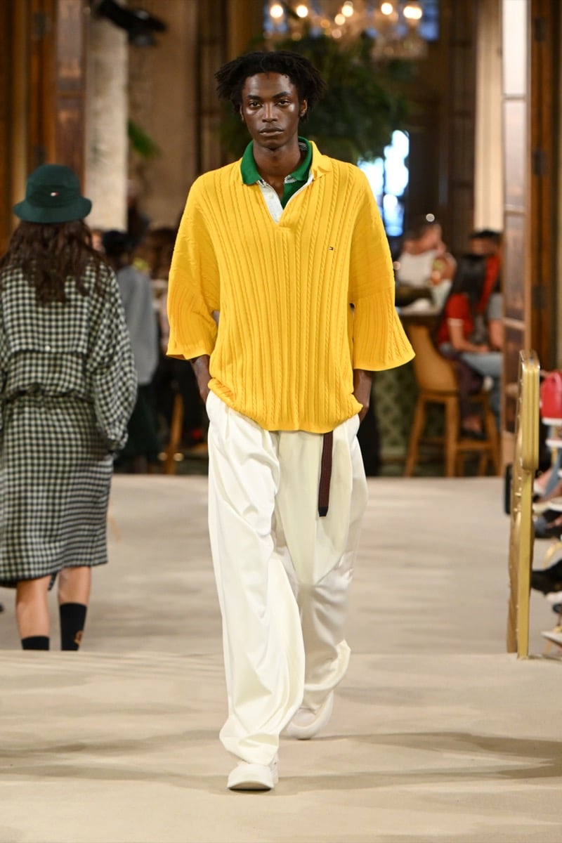 A model in a mustard cable-knit polo over a green collar, with light wide-leg trousers, for Tommy Hilfiger's spring 2027 collection