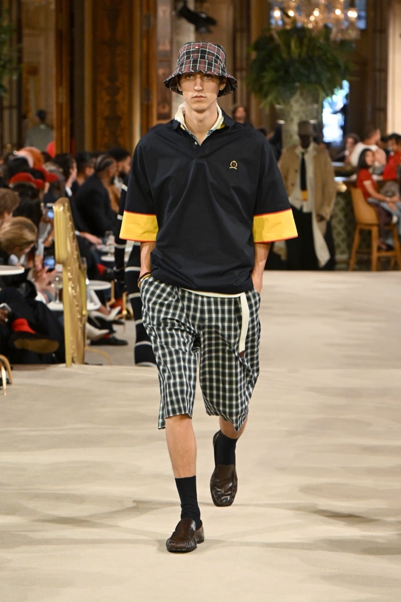 A model in a plaid bucket hat and polo shirt with plaid shorts, styled with brown loafers, for Tommy Hilfiger's spring 2027 collection