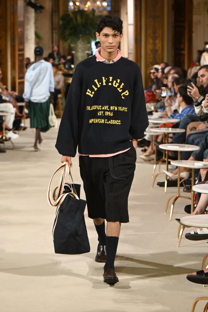 A model in a ribbed sweater with a collegiate 'Hilfiger' graphic over a pink polo, paired with shorts, for Tommy Hilfiger's spring 2027 collection