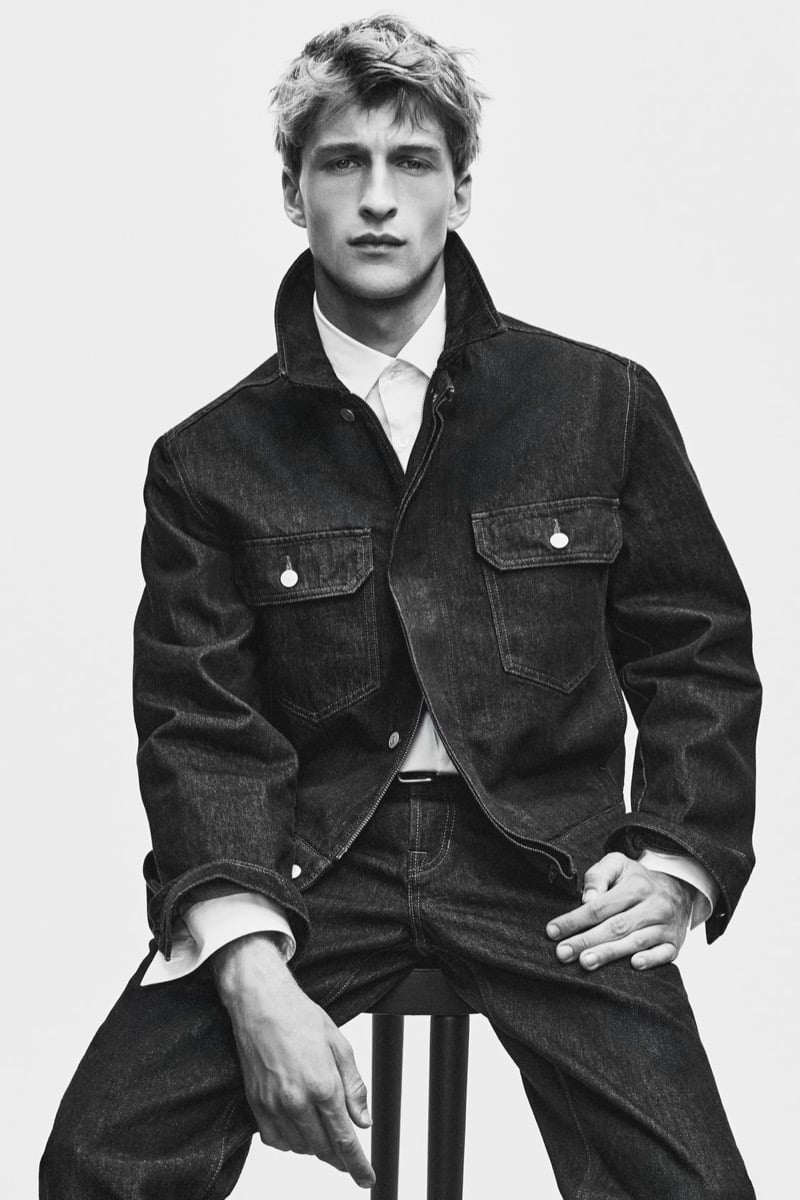Vasko Luyckx seated in a denim jacket layered over a collared shirt for Zara's 90's Archive