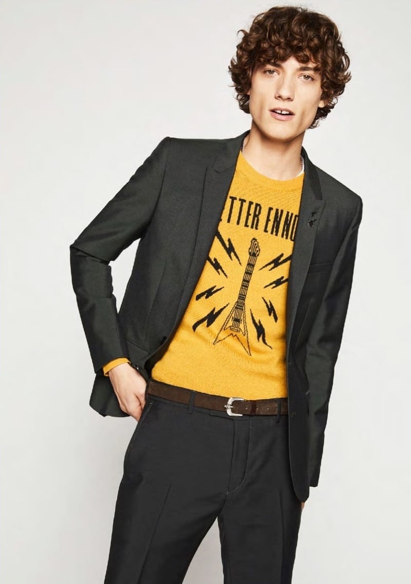 Serge Rigvava wears a fitted blazer and yellow guitar-motif sweater for The Kooples spring 2018.