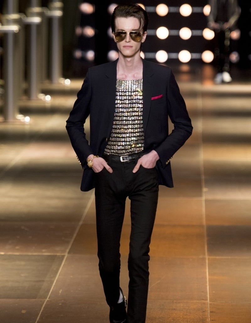 Saint Laurent spring 2014 runway look with a fitted black blazer, glittering top, skinny trousers and boots.