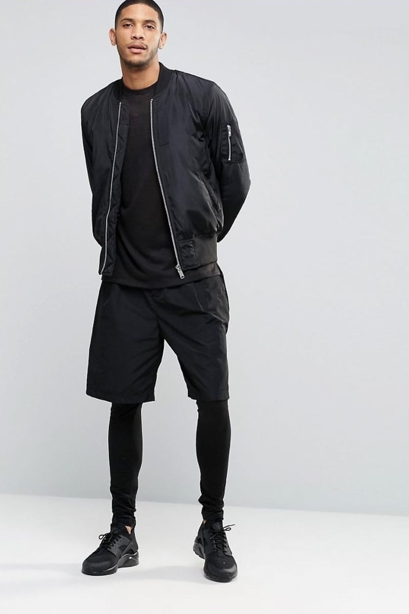 ASOS black leggings worn beneath shorts with a black bomber jacket and sneakers in 2016.
