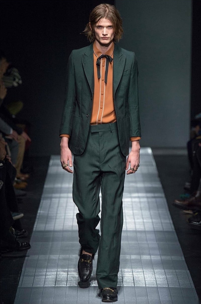 Gucci fall 2015 green suit with an orange bow-tied shirt and loafers.