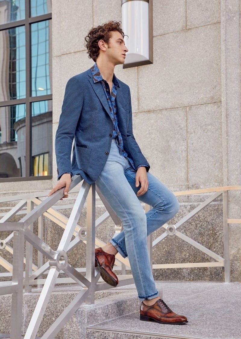 Niels Trispel wears a blue Luciano Barbera blazer, patterned shirt, cuffed Marco Pescarolo jeans and brown Harris leather shoes for Barneys New York spring 2018.