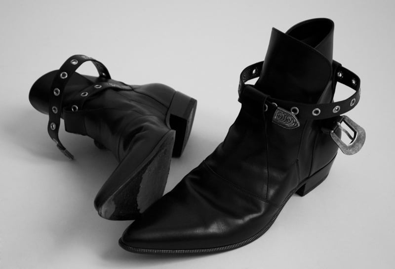 Black Saint Laurent pointed-toe leather ankle boots with silver western buckles photographed in 2014.