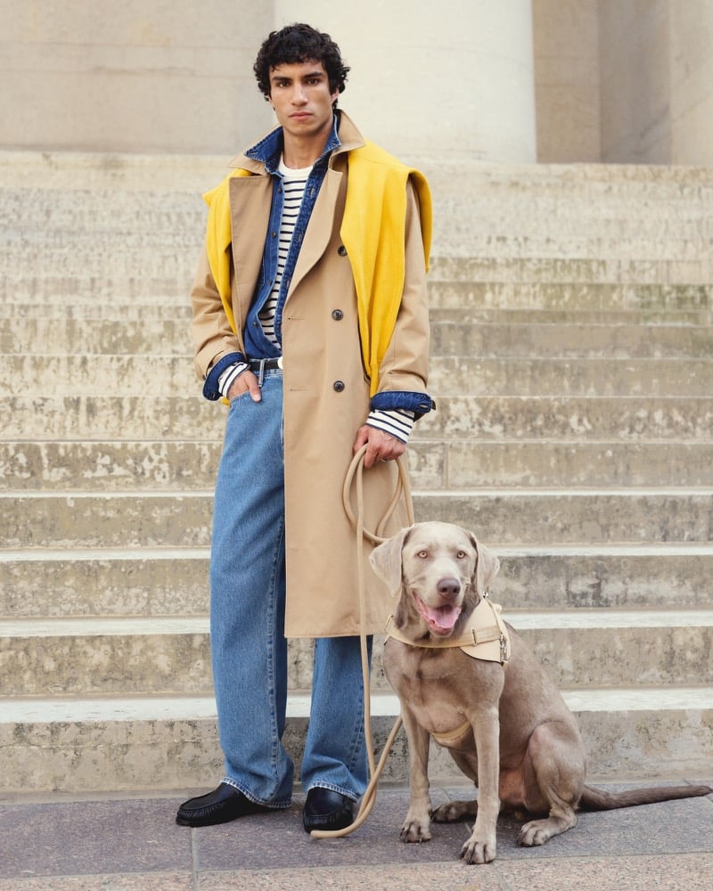 Duncan Yair wears Abercrombie & Fitch’s camel trench coat over a striped top and blue jeans, with a yellow sweater draped over his shoulders.