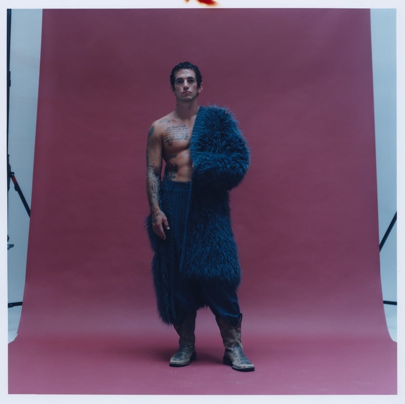 Alex Fine stands in a blue Dolce & Gabbana coat and trousers with his own cowboy boots.