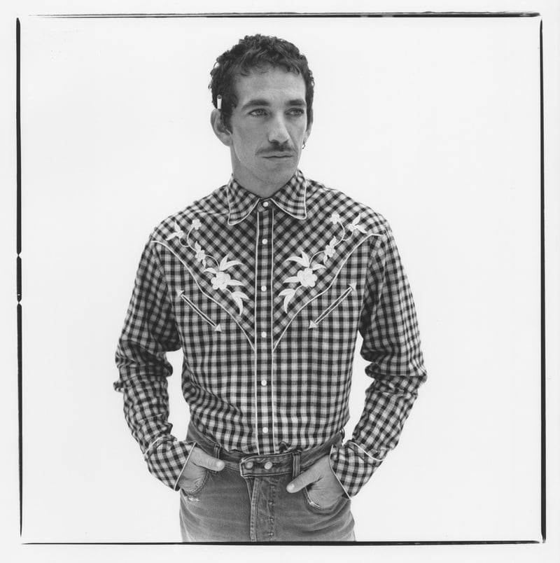 Alex Fine wears a checked Kenzo shirt, Diesel jeans, and an IWC watch in a black-and-white portrait.