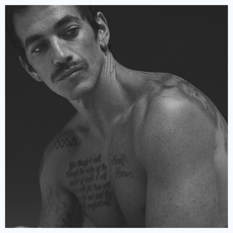Alex Fine poses shirtless in a black-and-white close-up.
