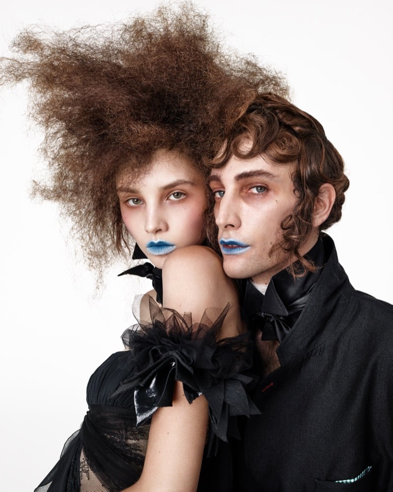 Close-up of Anna Bicanova in a black tulle-trimmed dress and Thomas Riguelle in a black jacket and neck bow, both with light blue lips