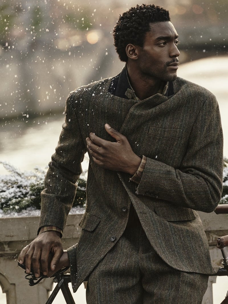 Halid Nuhu wears a textured suit outdoors in the snow.