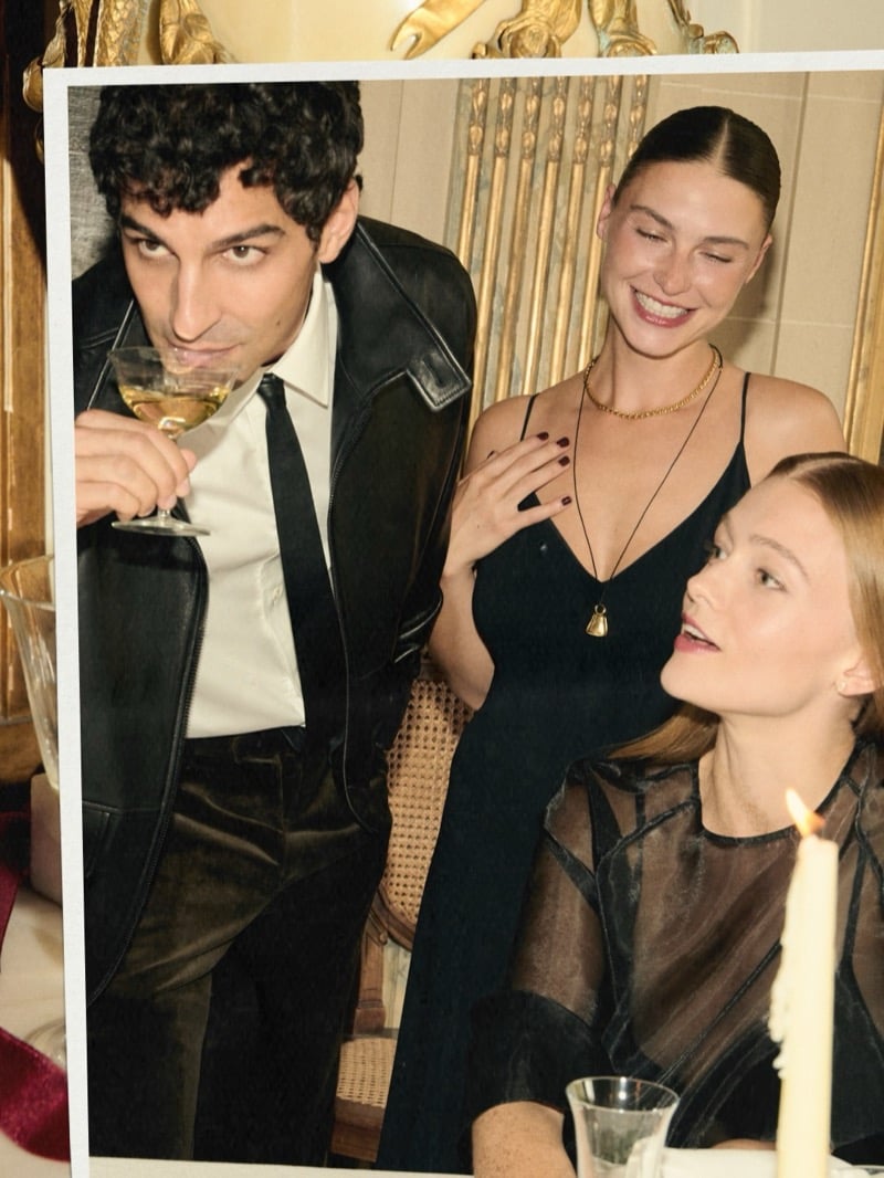 Francisco Faria joins two women at a table in a candid party photograph.