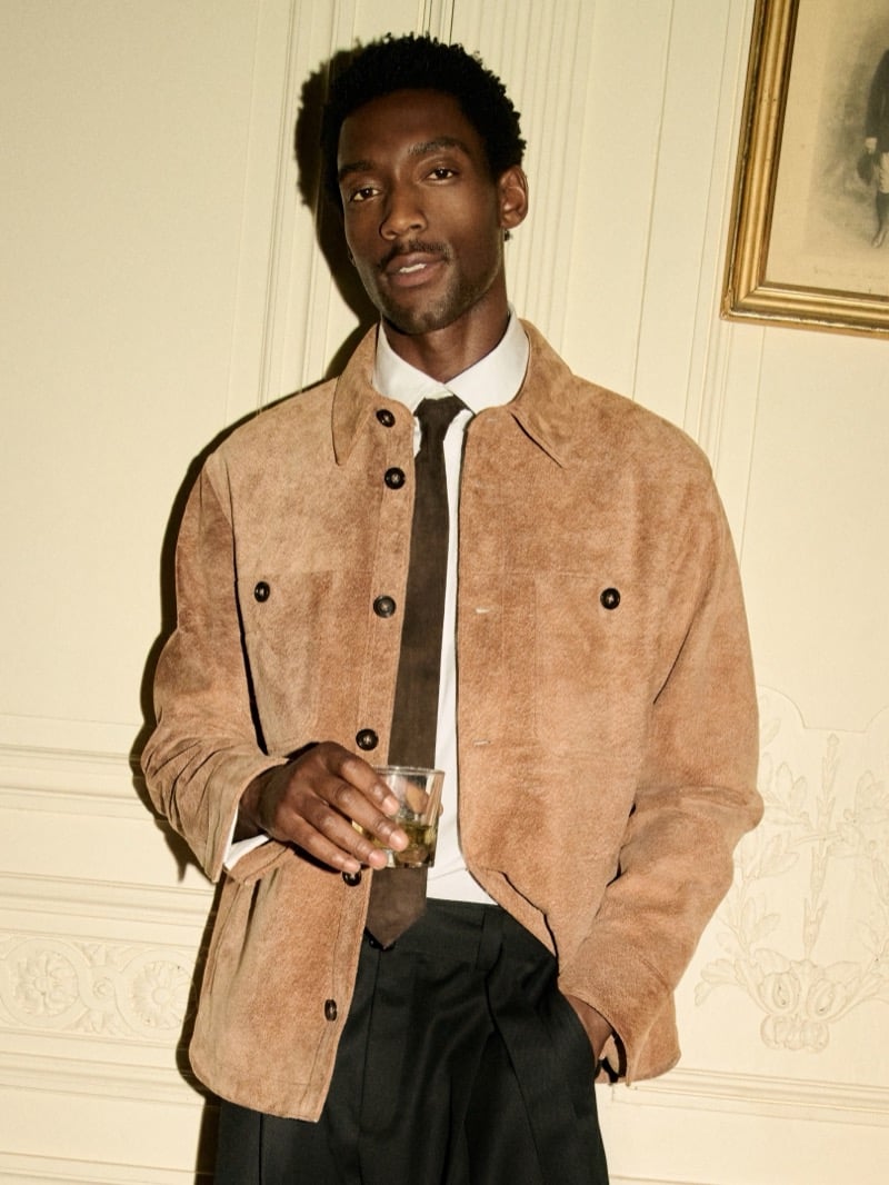 Halid Nuhu wears a tan suede shirt jacket over a white shirt and dark tie.