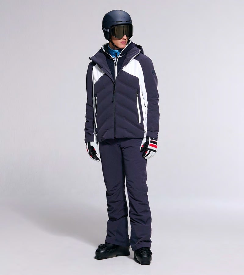 A model wears a navy ski jacket with white panels and matching navy trousers. Bogner fall-winter 2026 collection.