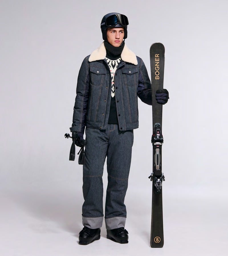 A model wears a denim-look ski jacket with a cream collar and matching ski trousers. Bogner fall-winter 2026 collection.