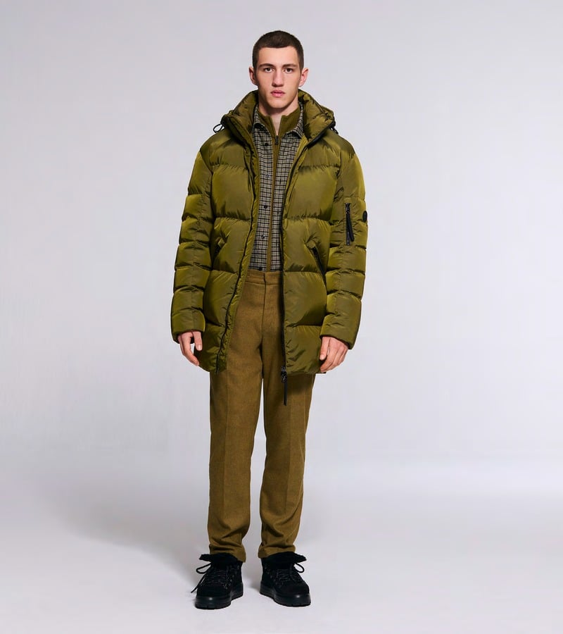 A model wears an olive padded jacket over knitwear with coordinating trousers. Bogner fall-winter 2026 collection.