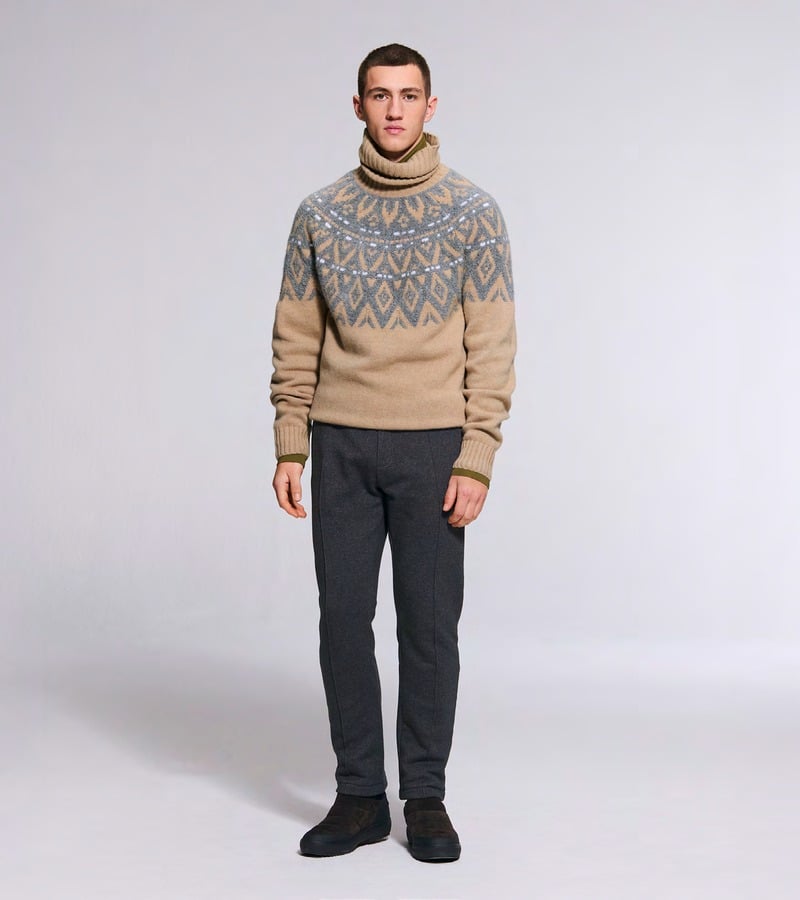 A model wears a cream turtleneck with a gray patterned yoke and dark trousers. Bogner fall-winter 2026 collection.