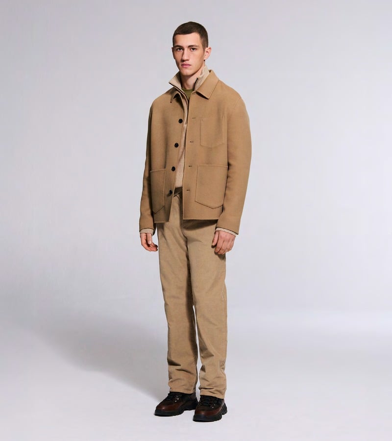 A model wears a tan button-front jacket with coordinating trousers and brown shoes. Bogner fall-winter 2026 collection.