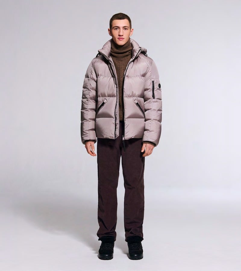 A model wears a dusty pink padded jacket over a brown turtleneck with burgundy trousers. Bogner fall-winter 2026 collection.