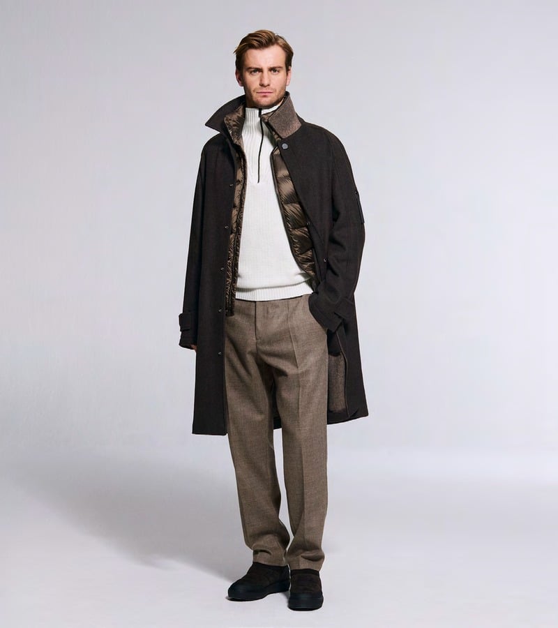 Ben Allen wears a dark coat over a white sweater with taupe trousers. Bogner fall-winter 2026 collection.