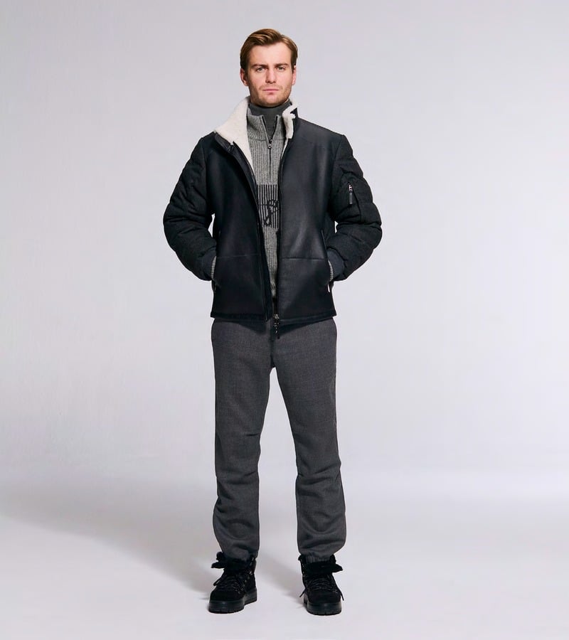 Ben Allen wears a black jacket with a pale collar over gray knitwear and trousers. Bogner fall-winter 2026 collection.