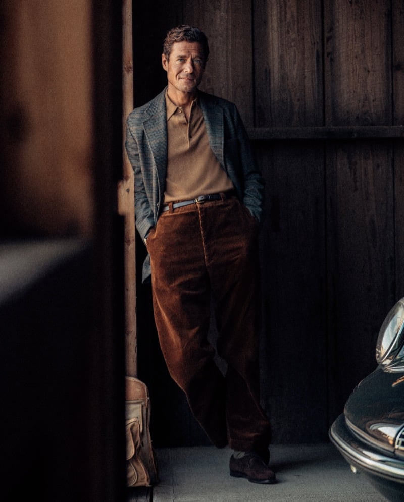 Jon Paul Phillips wears a checked jacket with a knit polo and corduroy trousers for Buck Mason's fall 2026 collection.