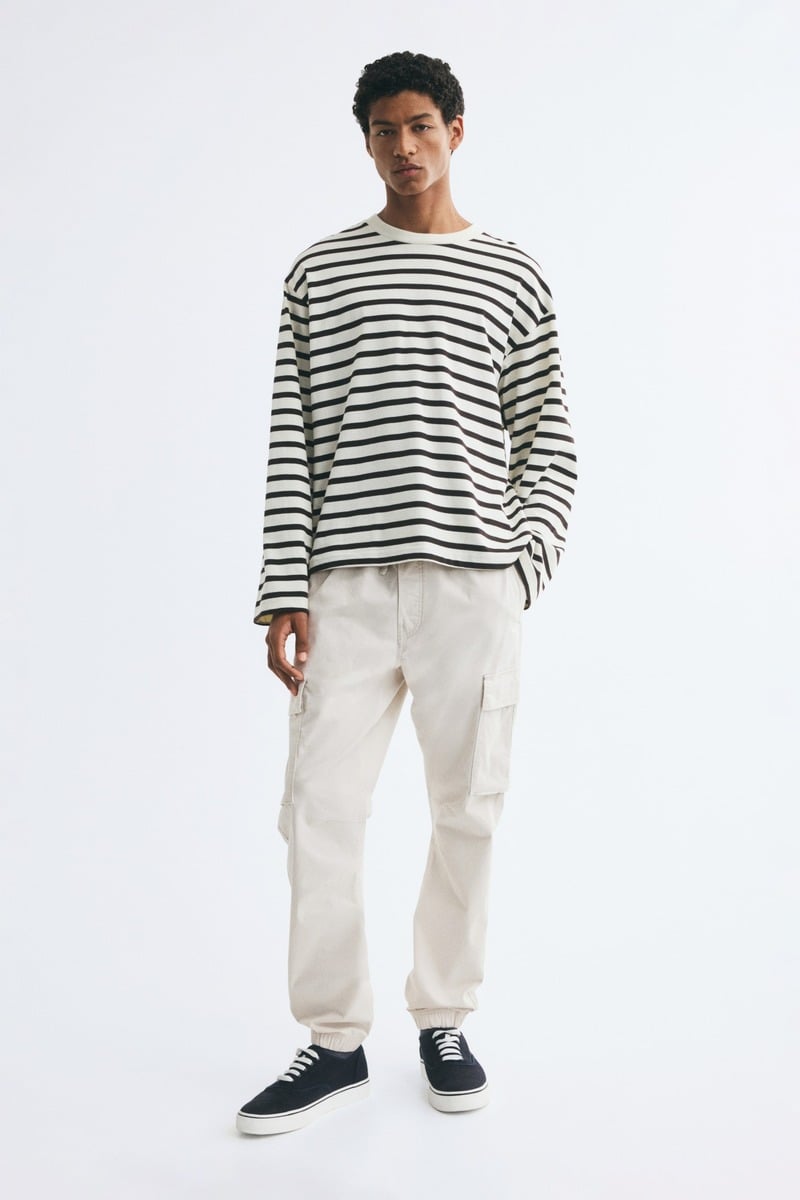 Black-and-white striped long-sleeve shirt, light beige cargo joggers and black canvas sneakers from H&M.