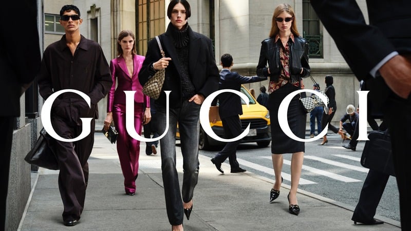 Joseph Rodriguez, Anna Robinson, Charlie Jones and Vivian Wilson cross a New York street in GucciCore tailoring and leather, with a bright pink suit among the looks. Gucci logo across the photograph.