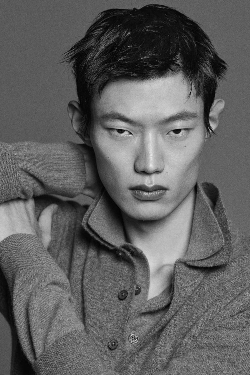 Hoyong Kim wears a gray cashmere polo in a black-and-white portrait.