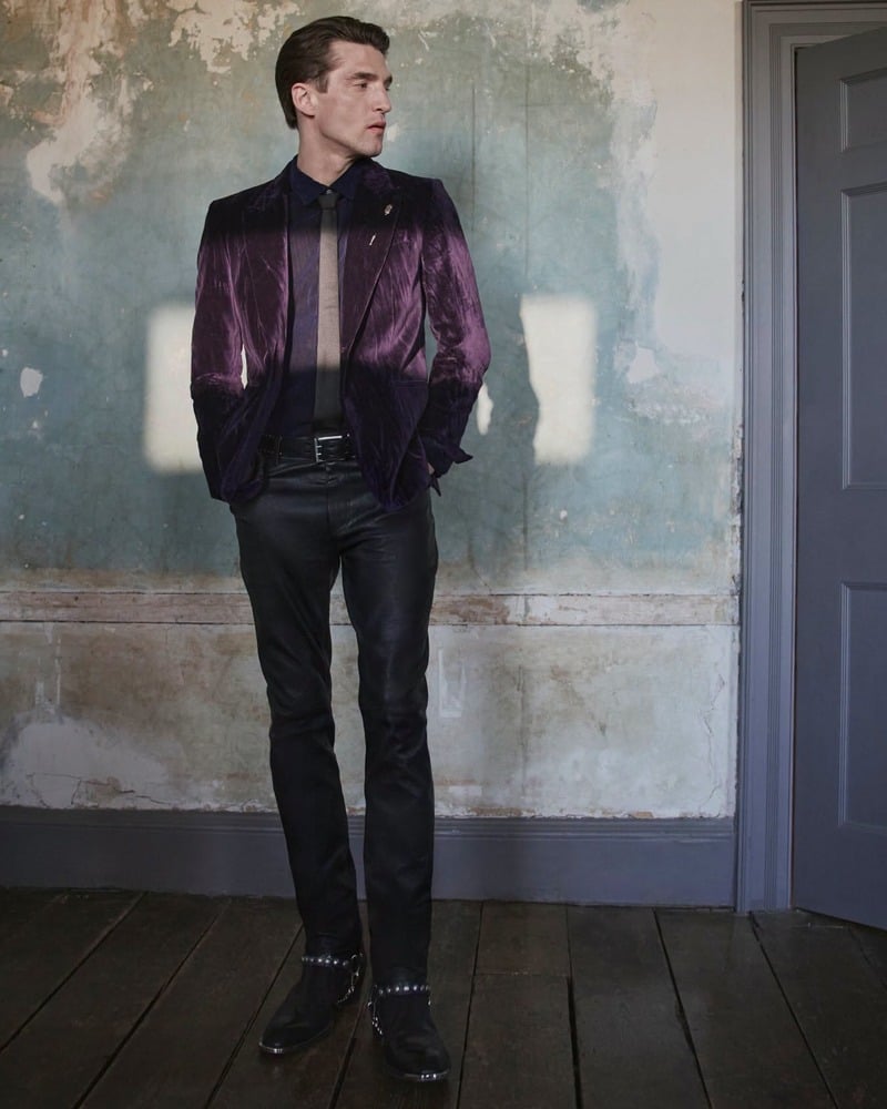 Anatol Modzelewski stands in a purple velvet jacket and slim dark trousers for John Varvatos' fall-winter 2026 campaign