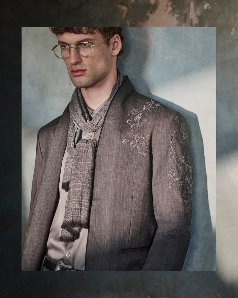 David Trulik wears glasses, a scarf, and the Bissell jacket in an inset portrait for John Varvatos' fall-winter 2026 campaign