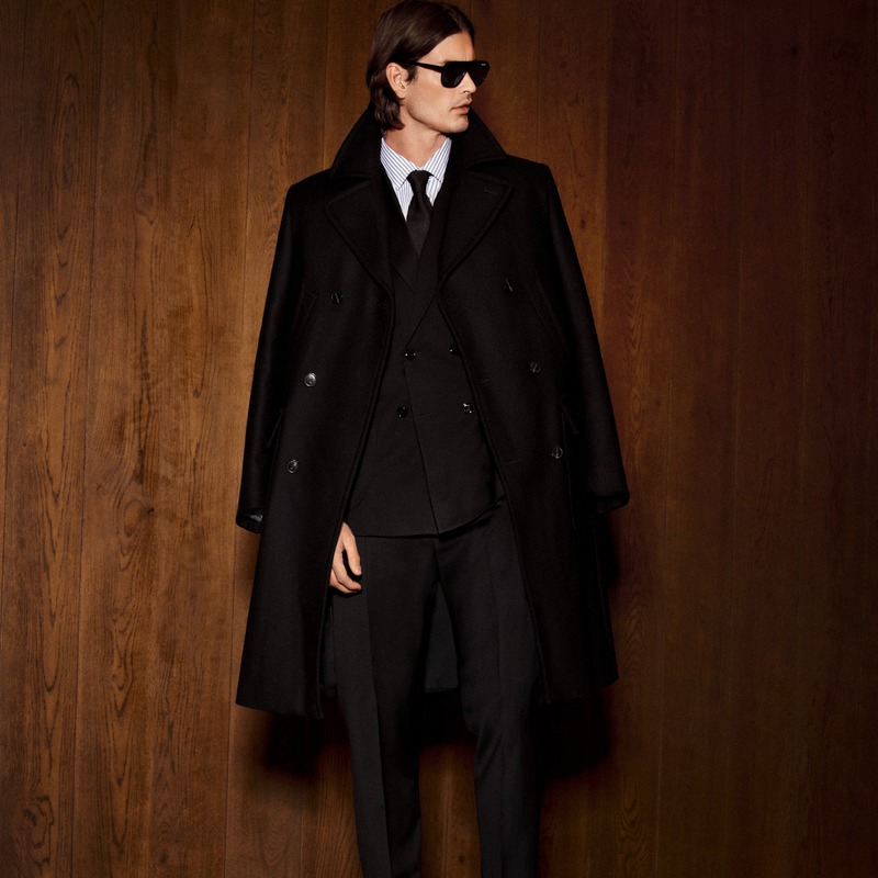Harrison Page wears a black overcoat with a double-breasted suit, tie, and sunglasses for JOOP!.