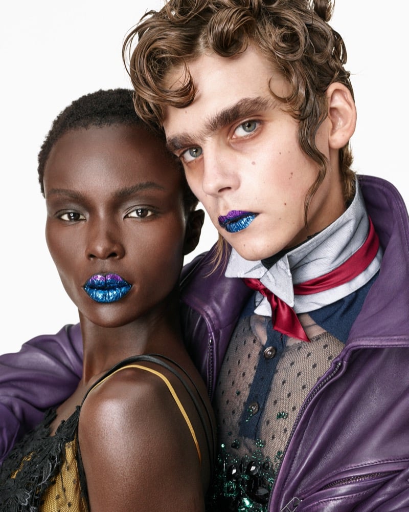 Close-up of Josephen Akuei and Frederic Bittner in a purple leather jacket and ribboned neck scarf, both with metallic blue lips