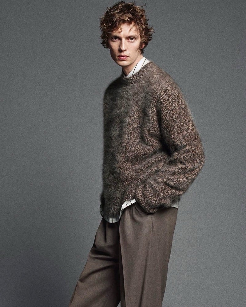 Leon Dame pairs a two-tone brushed cashmere sweater with a striped shirt and pleated trousers.