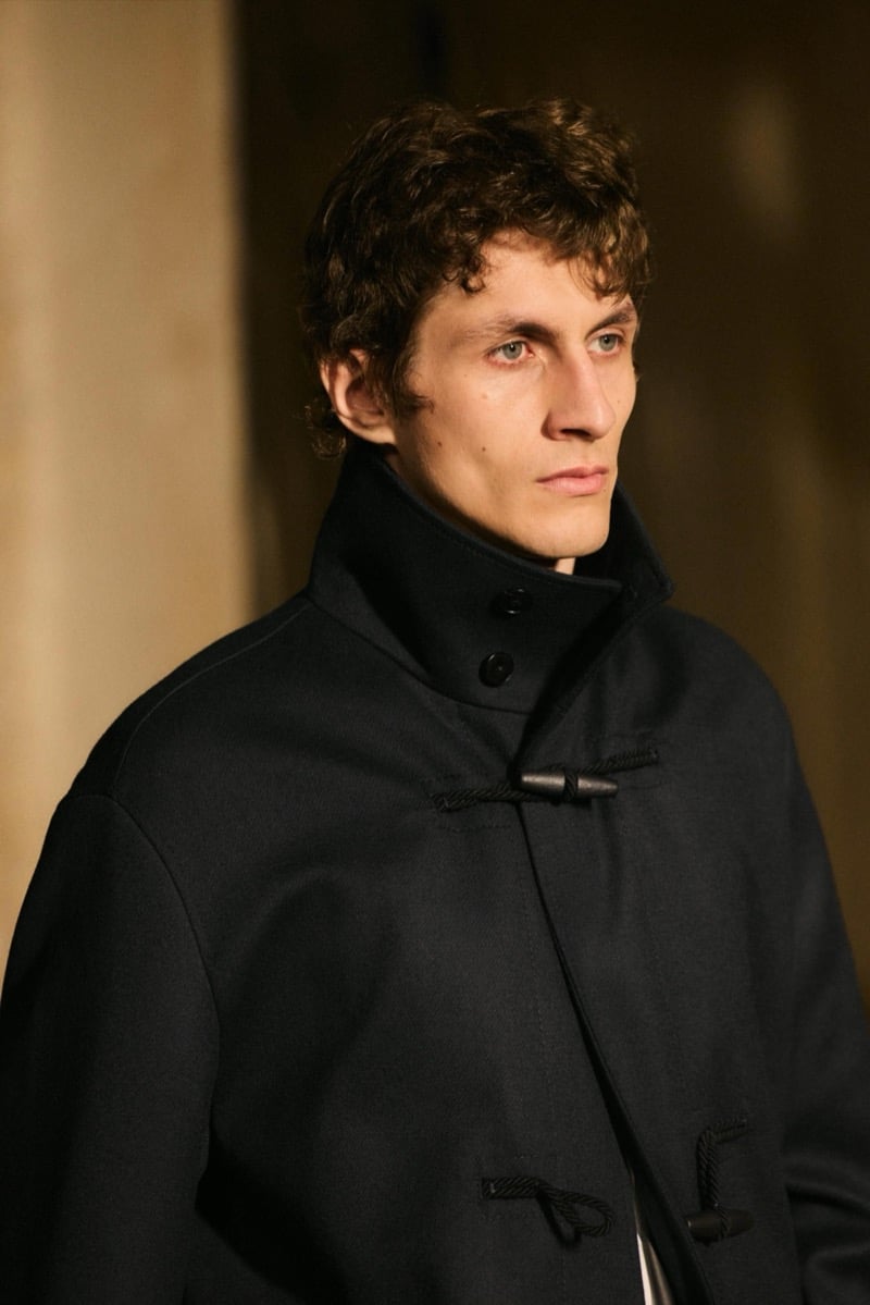 Massimo Dutti Limited Edition fall-winter 2026: Close-up of a model wearing a black high-collar coat with toggle fastenings.