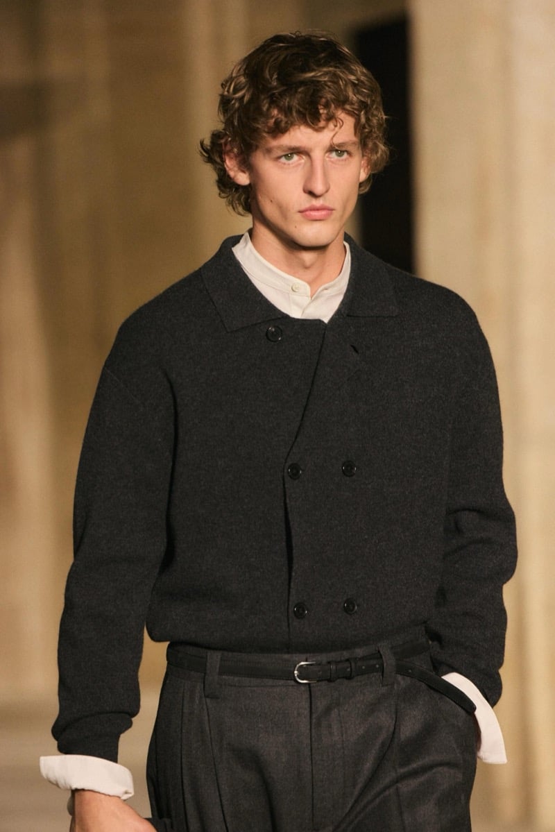 Massimo Dutti Limited Edition fall-winter 2026: Close-up of a dark buttoned cardigan, white shirt, and belted charcoal pleated trousers.