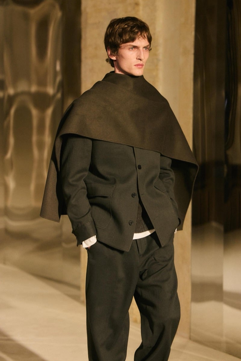 Massimo Dutti Limited Edition fall-winter 2026: Model wears an olive jacket and trousers with a brown scarf wrapped around his shoulders.