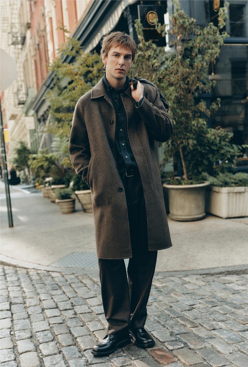 Quentin Demeester wears a long brown coat on a tree-lined New York sidewalk for Massimo Dutti's fall 2026 New York edit.