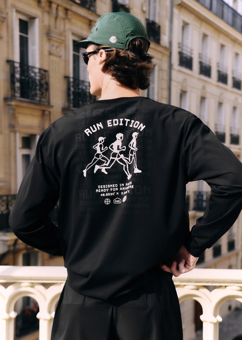 Myles Crosby showing the illustrated Run Edition graphic on the back of a black long-sleeve top