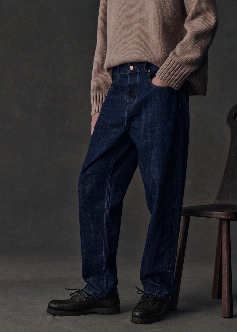 Sanggun Lee wears dark wide-leg Barkley jeans with a taupe sweater and black shoes.