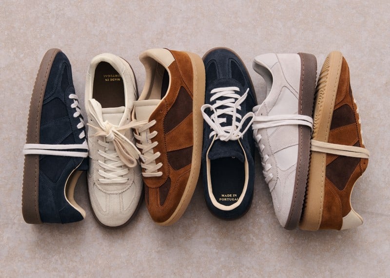 Octobre Éditions Halrin sneakers in navy, white, and camel chocolate are arranged on a textured surface.
