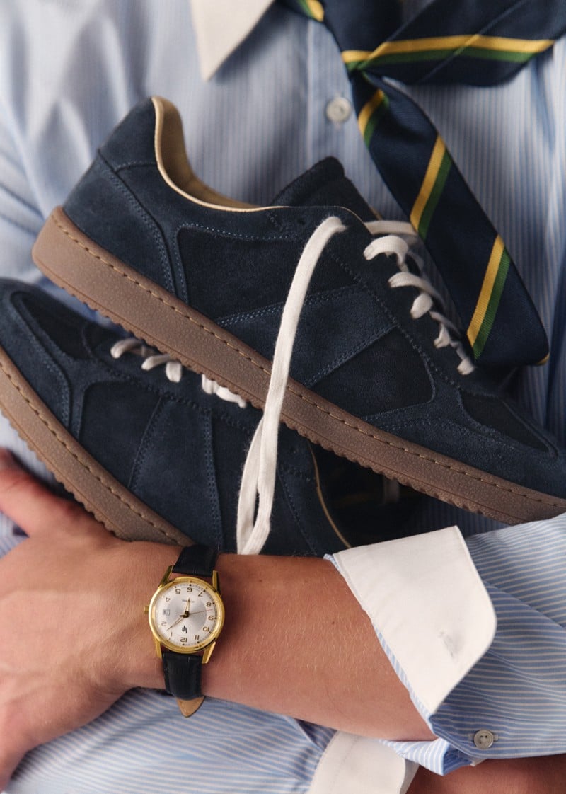 Max Turland holds navy Octobre Éditions Halrin sneakers against his shirt.
