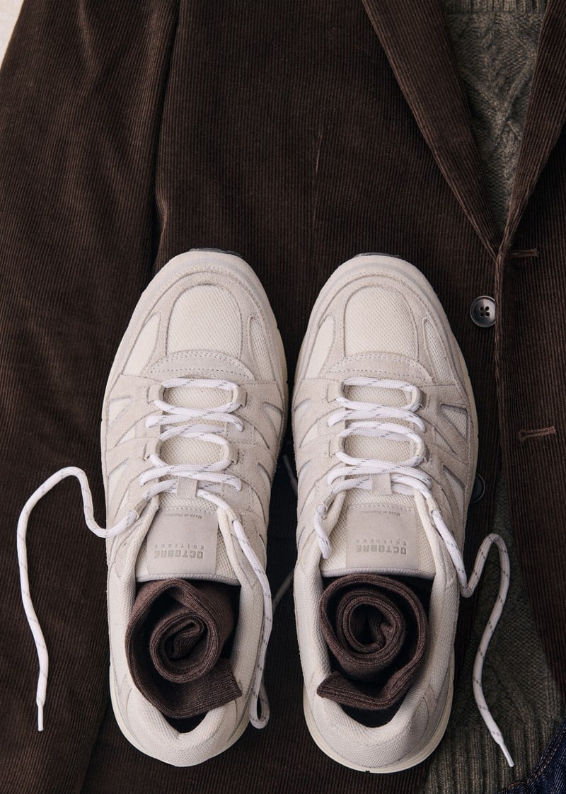 White Halrin sneakers are displayed against dark clothing.
