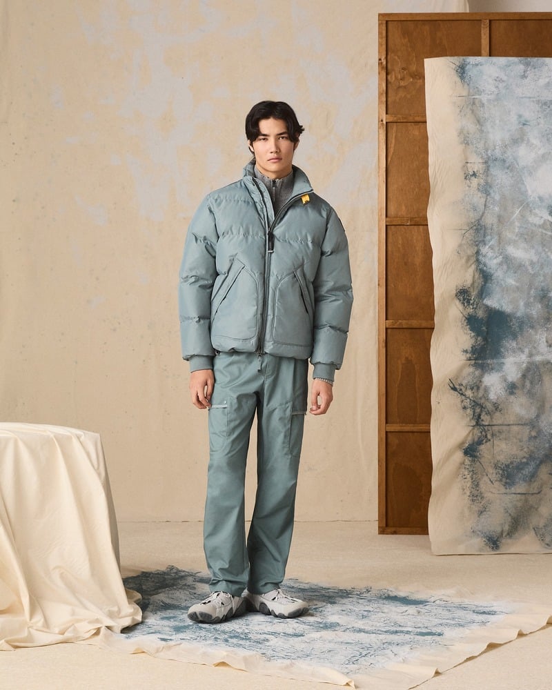Model wears a blue-green Parajumpers padded jacket with coordinating trousers.