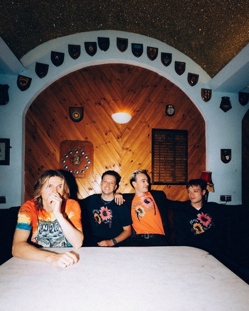 Legss gathers around a pub table wearing graphic T-shirts from Paul Smith + Fender.