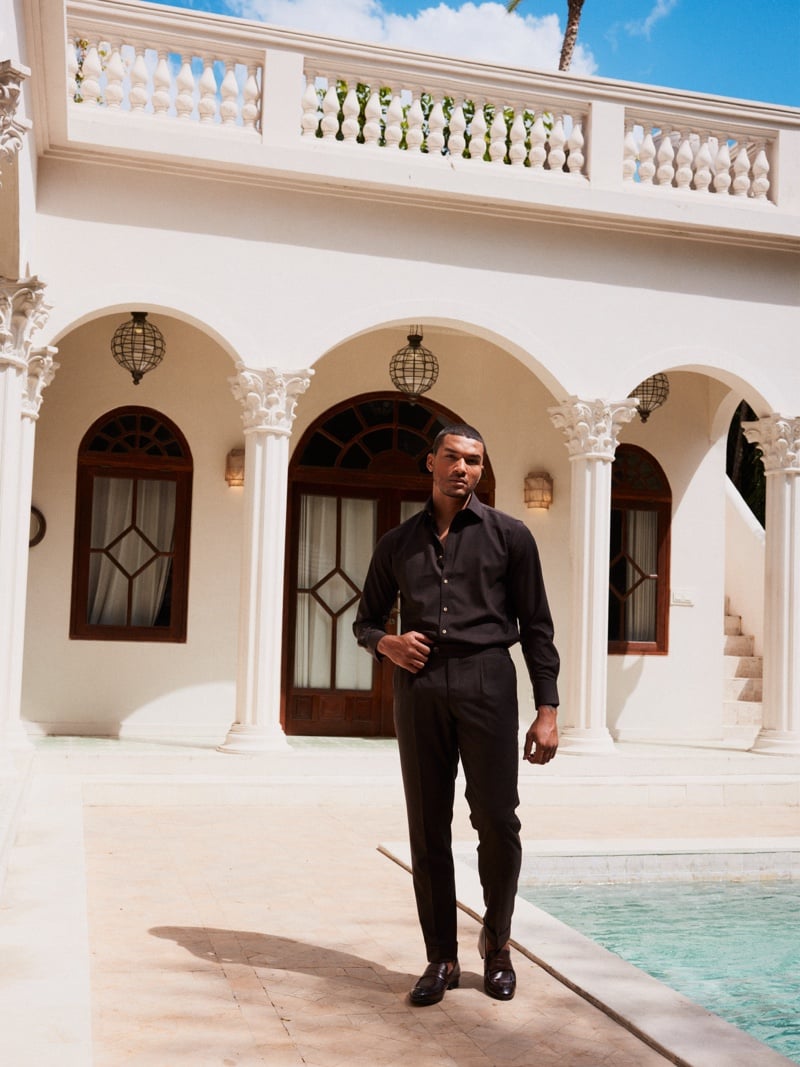 Gonçalo Campos wears a dark shirt and matching trousers beside a courtyard pool.